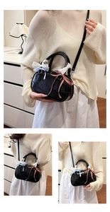 Detail of black glossy leather Boston bag with lace handles and bow tie decorations