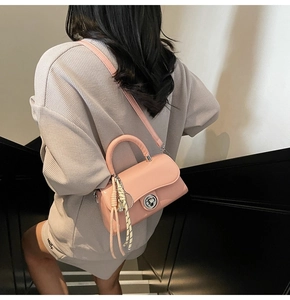 Sac bandoulière rose minimaliste avec poignée et détail en corde tressée sur modèle