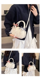 Detail view of white Boston bag with lace trim and plaid bowknot decorations
