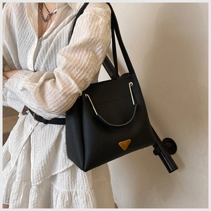 Close-up of the black lychee texture leather bucket bag with golden hardware detail