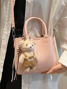 Pink oil wax leather bucket bag with bear charm and adjustable shoulder strap for women