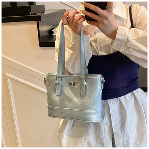 Detail of light blue quilted leather bucket bag with metallic twist lock and top handles