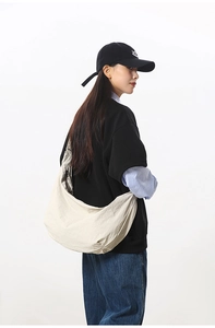 Detail view of the large beige nylon crescent bag showing its spacious capacity and texture