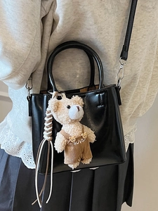 Classic black oil wax leather bucket bag with a cute plush bear pendant on model
