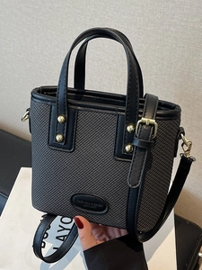Sac seau chic en texture tressée noire avec écusson en cuir et bandoulière réglable