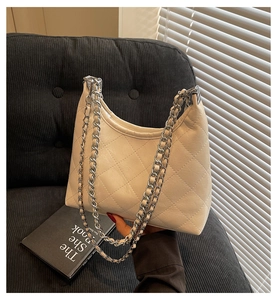 Nahaufnahme der cremefarbenen gesteppten Hobo-Tasche mit silberner Kette