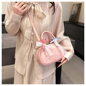Detail of pink Boston bag with lace trim and vibrant checkered bows on the handles