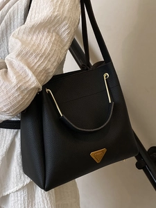Elegant black lychee leather handbag with golden Prada logo and curved top handle