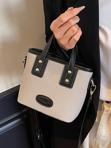 Sac seau beige tissé élégant avec garniture en cuir noir et détails en métal doré