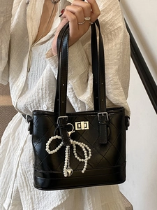 Quilted black bucket bag with pearl bow charm and metal heart detail for women