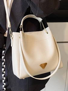 Cream lychee textured leather bucket bag with gold hardware and top handle strap