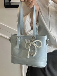 Quilted light blue bucket bag with pearl bow charm and silver heart pendant