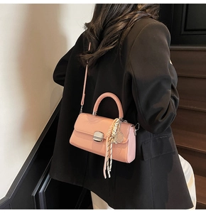 Pink patent leather crossbody bag with silver twist lock and tennis racket charm detail