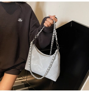Detail der weißen gesteppten Kunstledertasche mit silberner Kette im Hobo-Stil