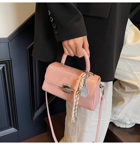 Pink patent leather crossbody bag with silver lock and decorative silk scarf detail