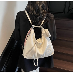 Detail view of cream patent leather tote with decorative scarf and mini coin purse