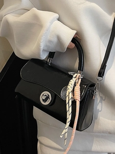 Sac à main minimaliste en cuir verni noir avec fermoir rotatif argenté et breloque