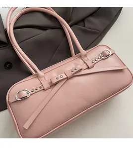 Close-up of pink leather bowling bag featuring silver buckle straps and rivet details
