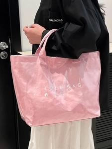 Modern pink wrinkled tote bag with white text print shown held by a fashion model