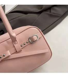 Close-up of pink leather handbag with silver metallic buckle and rivet detailing