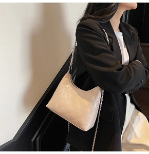 Beige gesteppte Hobo-Tasche mit Kettenriemen kombiniert mit einem schwarzen Business-Blazer