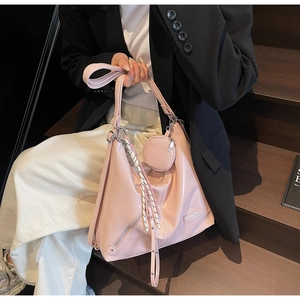 Detail of pink PU leather hobo bag with mini coin purse and woven rope decorative pendant
