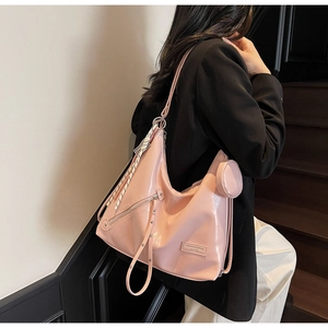 Pink glossy hobo bag detail with metal rivets, coin purse and striped ribbon accent