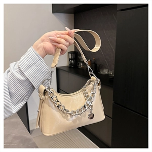 Detail of cream oil wax leather shoulder bag with chunky silver chain and metal charm