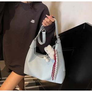 Detail of light blue lychee pattern tote bag with chain strap and cloud charm