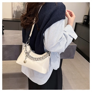 Detail of ivory oil-wax leather underarm bag with bold silver chain and smooth finish