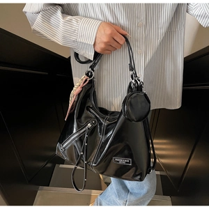 Detail of black glossy faux leather tote bag featuring a detachable round coin purse