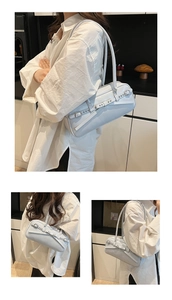 Detail view of smooth leather underarm bag featuring silver buckle and strap accents