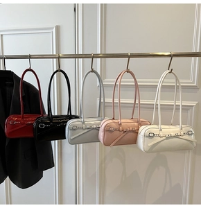 Detail view of colorful glossy faux leather underarm bags with stylish bow buckle straps