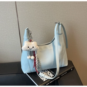Close-up of light blue lychee pattern leather hobo bag with a white plush cloud charm