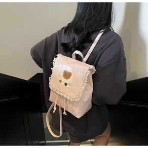 Pink PU leather backpack with lace trim and bear patch detail shown on female model
