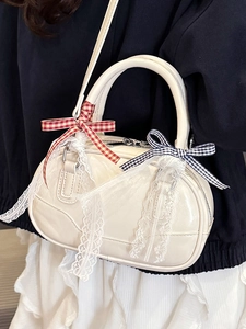 Minimalist cream white Boston handbag with lace details and plaid bows shown on model