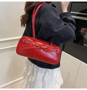 Close-up of a red patent leather bowling bag with bow details and silver buckles