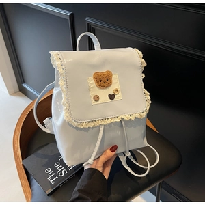 Close-up of light blue PU leather backpack with lace trim and cute bear patch detail