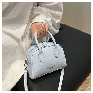 Macro detail of a light blue lychee pattern leather Boston bag featuring FANTOOF metal logo