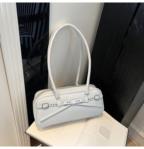 Detail of white glossy bowling bag with rivet bow and silver buckle on a magazine