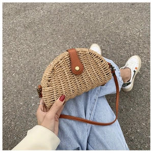 Detailed macro view of woven straw texture and brown leather strap on summer bag