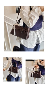 Dettaglio borsa a mano in pelle marrone scuro con fiocco vintage e nastro di pizzo