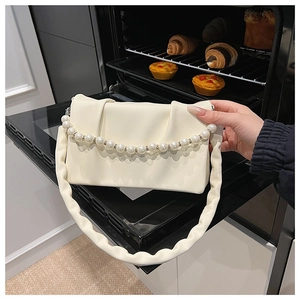 Détail du sac à bandoulière crème plissé français avec chaîne en perles et sangle nuage