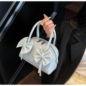 Détails du sac Boston bleu clair avec nœuds décoratifs et fermeture éclair argentée élégante