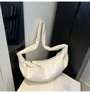 Detail of soft off-white pleated hobo bag with high-quality leather texture and strap