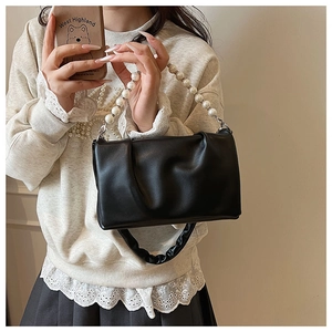 Détail du sac bandoulière plissé noir avec chaîne de perles et bandoulière froncée