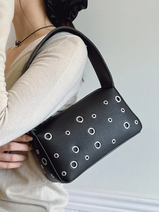 Chic black rivet shoulder bag with silver eyelets and wide strap for trendy style