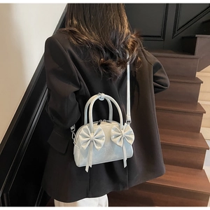 Vue détaillée d'un sac à main bleu clair avec nœuds et garnitures argentées