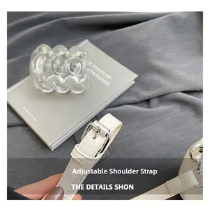 Détail de la bandoulière réglable en cuir blanc avec boucle argentée et couture fine