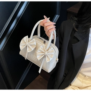 Détail du sac Boston blanc crème avec nœuds en cuir mat et rubans en relief 3D